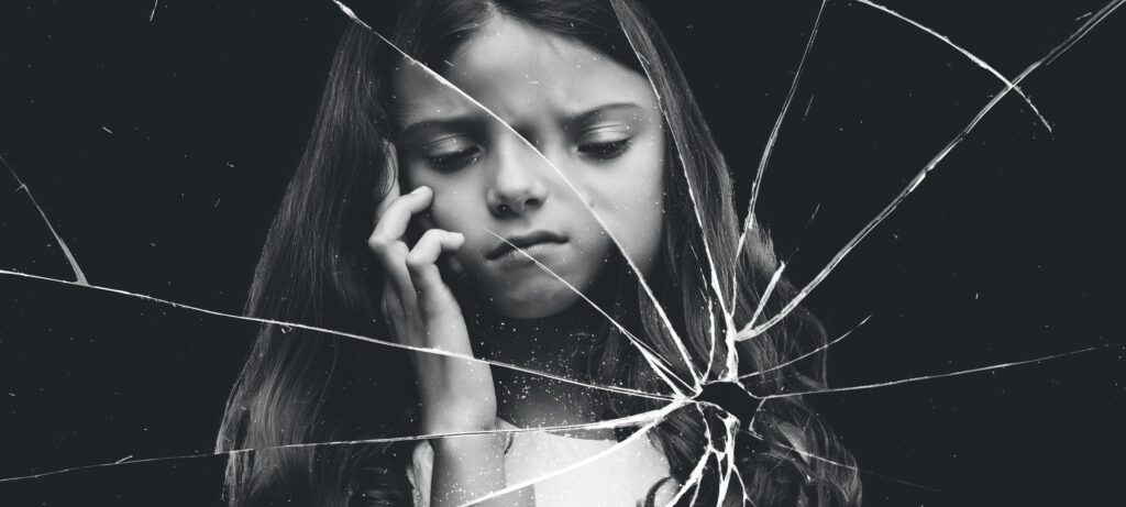 Photo of a young girl looking anxious with a filter of broken glass making her look distorted.