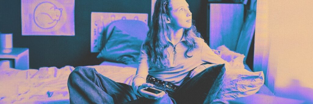 young girl with cell phone looking out window