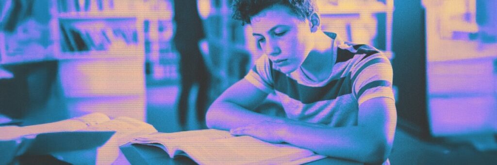 young boy studying a book