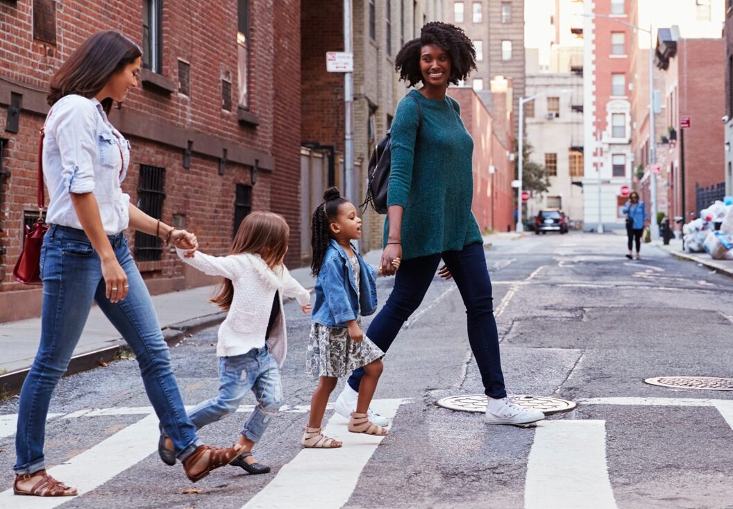 two moms on a walk with their little girls