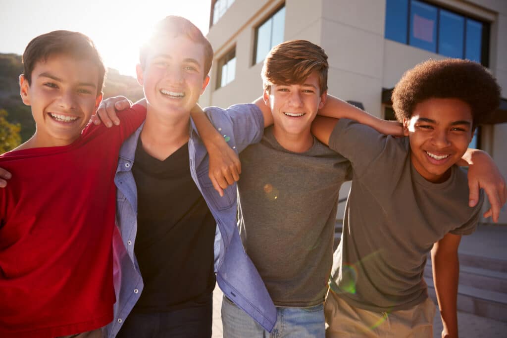 four teen boys with arms around each other