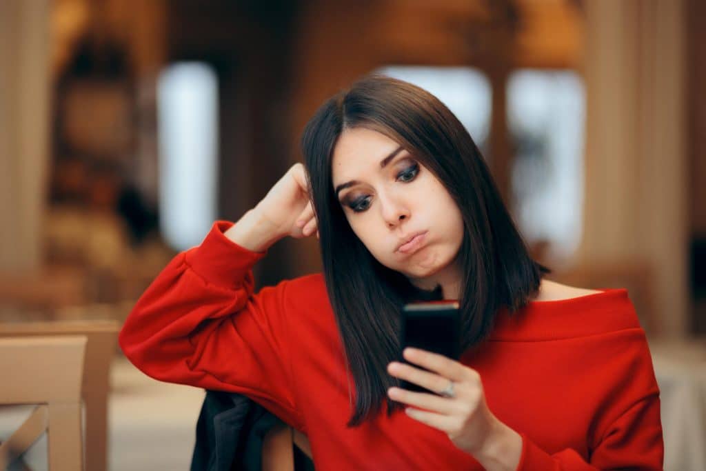 Bored Woman checking her smartphone on a date
