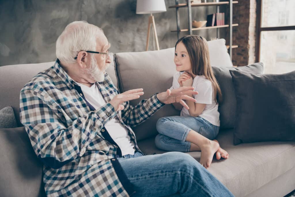 little girl listening to her grandpa tell a story