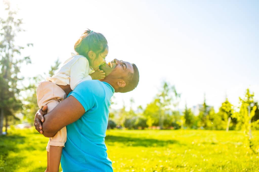 father and toddler laughing and hugging