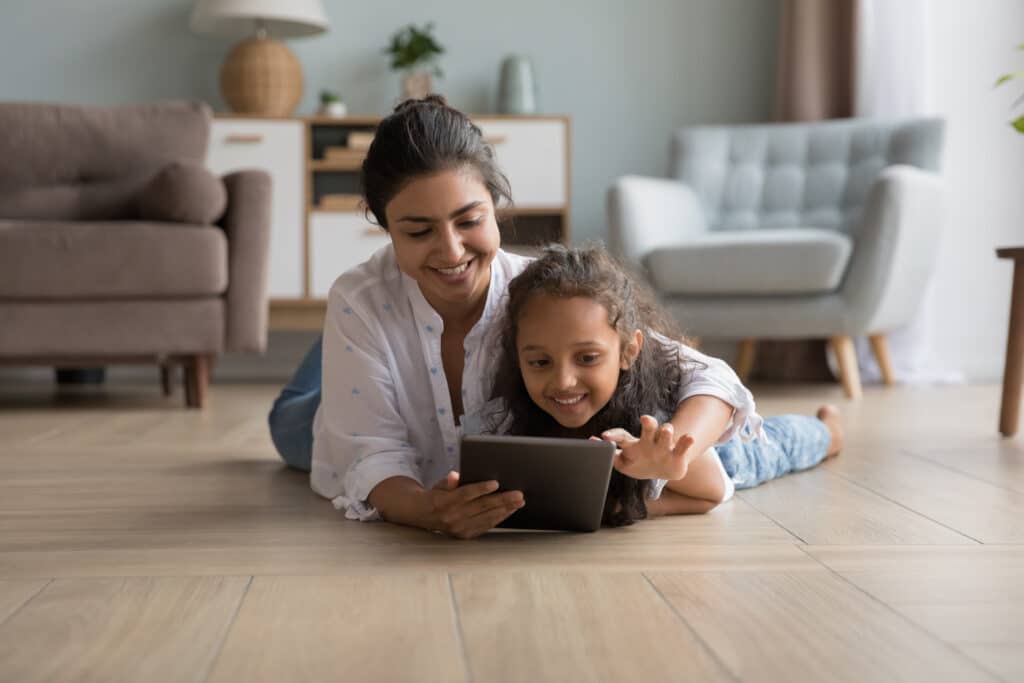 mom and daughter smiling at tablet
