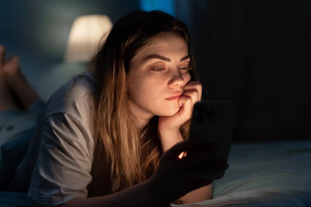 sad woman looking at smartphone screen