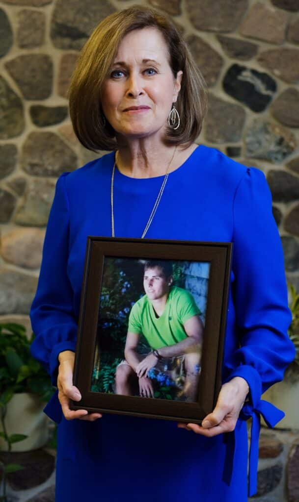 leslie weirich holding photo frame of her son austin