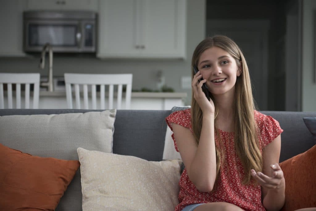 Happy teenage girl using Gabb Phone