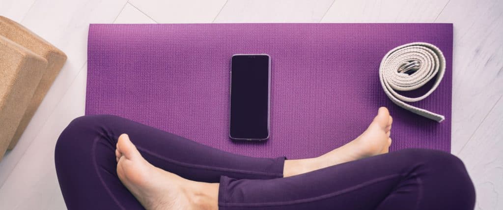 digital self care with phone and yoga mat