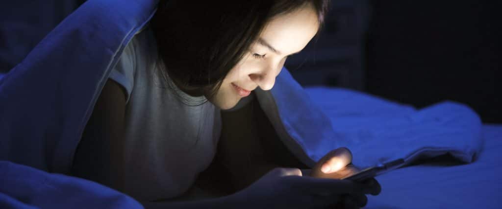 Teen girl looking at finsta and smiling