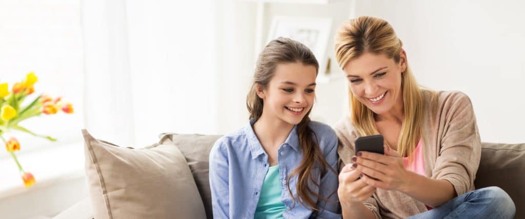 mom and daughter happy looking at phone
