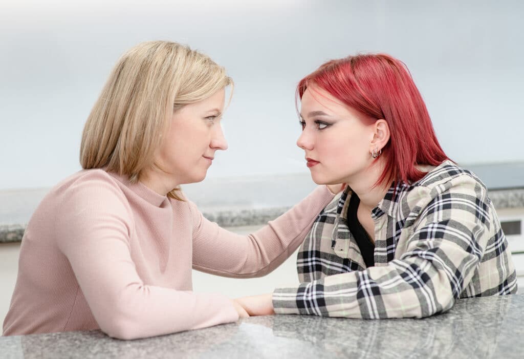 mother with hand on daughters shoulder
