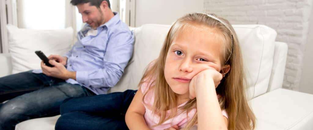father on phone with daughter looking bored