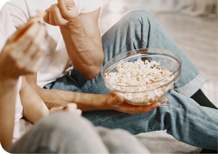 people eating popcorn out of a bowl
