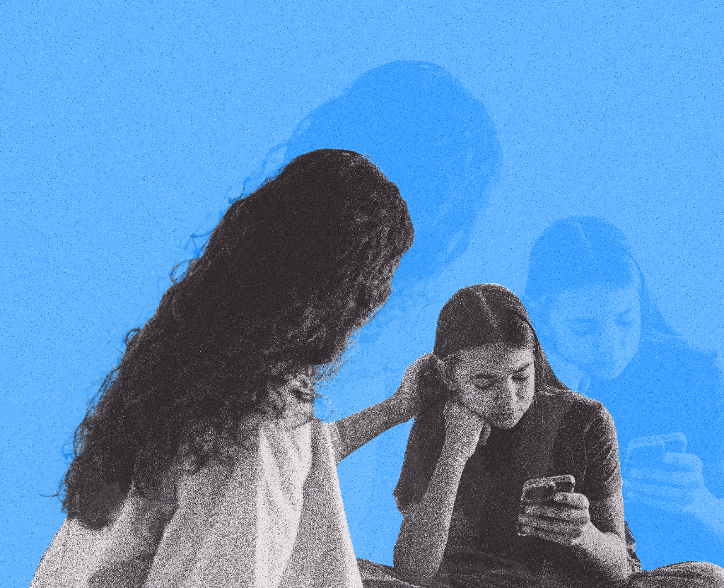 Mom with hand on daughter who is looking at her phone.