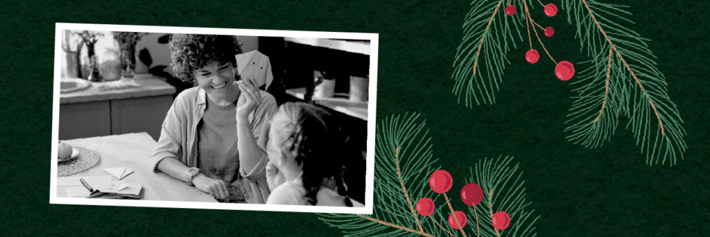 mom and daughter making origami around the holidays on a festive background