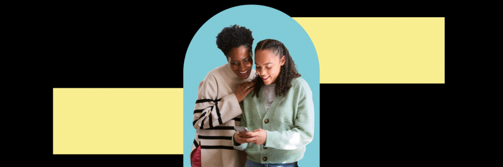 mom and daughter smiling at cell phone