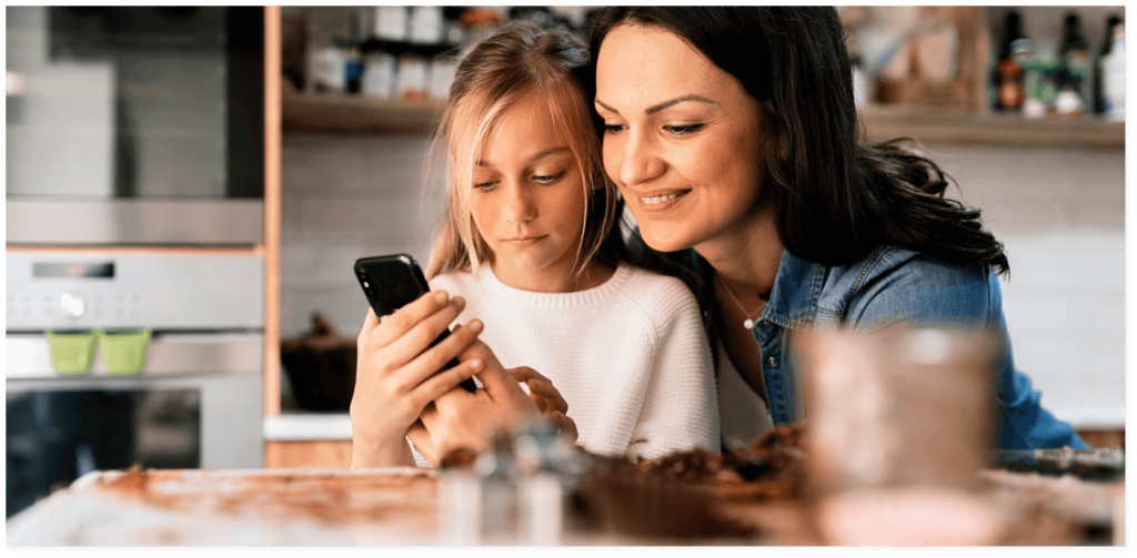 Mother and daughter looking at kid safe phone