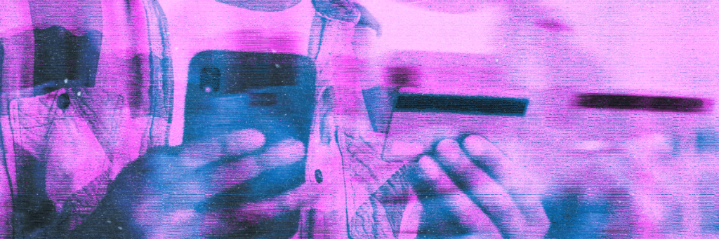 someone holding a cell phone and a credit card