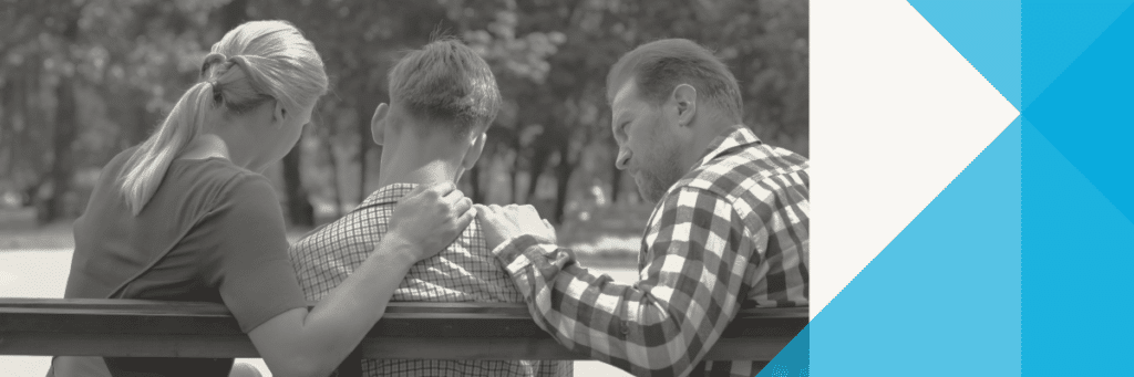 parents with hands on their son's shoulders