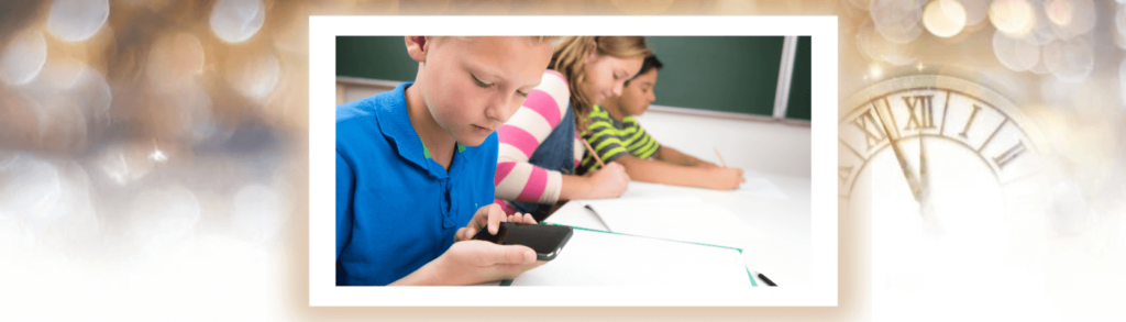 young boy looking at phone in class